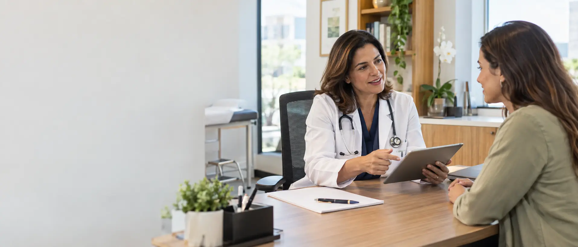 Médica conversando com uma paciente em consultório